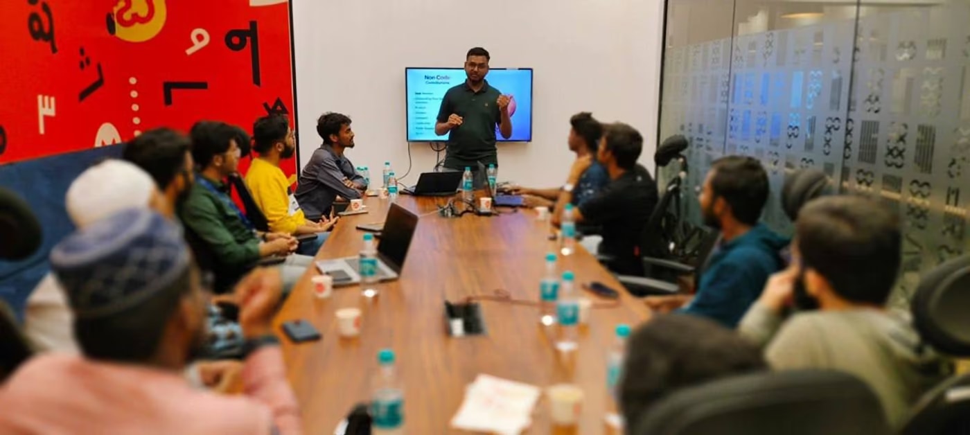 Joshua Poddoku speaking to a room around a boardroom table